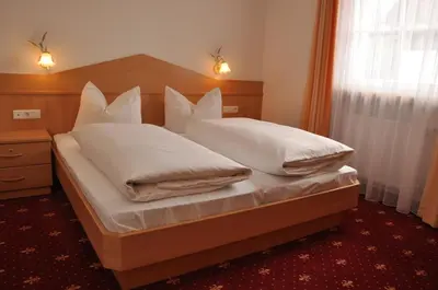 a bedroom with a bed with white sheets and pillows at Apartment Residence Volgger in Brunico