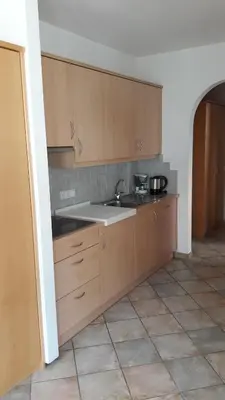 a kitchen with wooden cabinets and a sink at Apartment Residence Volgger in Brunico