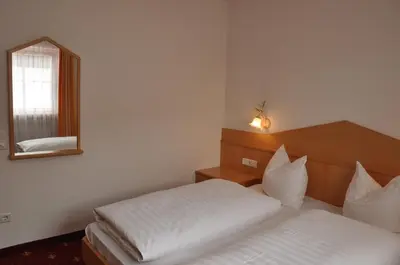 a bedroom with two beds and a mirror at Apartment Residence Volgger in Brunico
