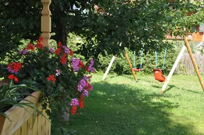 a garden with flowers and a swing at Apartment Residence Volgger in Brunico