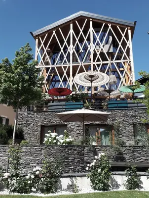 a building with a table and umbrellas on it at Messnerhaus Suite in Siusi