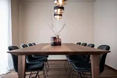 a dining room table with chairs and a vase on it at Messnerhaus Suite in Siusi