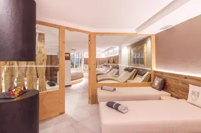 a living room with couches and tables in a room at Hotel Madonnina Resort And Wellness in Soraga