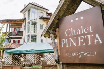 a sign in front of a building with a chatelet pinea at Chalet Pineta relax location in Canazei
