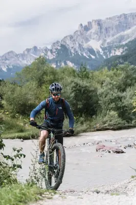 a man riding a bike down a mountain road at Chalet Pineta relax location in Canazei