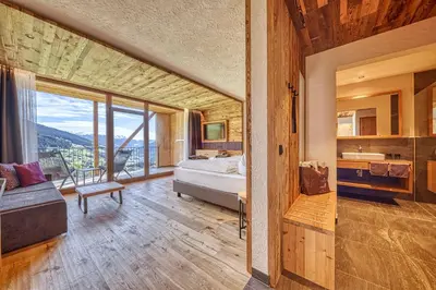 a bedroom with a bed and a large window at Erlebnisort Gassenhof in Ridanna