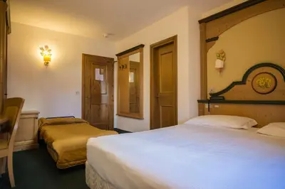 a bedroom with a bed with a teddy bear on it at Hotel Monzoni - San Pellegrino in Passo San Pellegrino