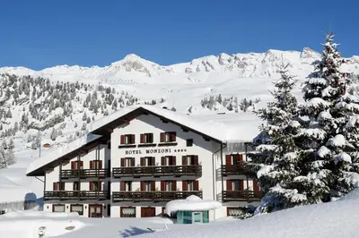 a large swimming pool in a building with a lobby at Hotel Monzoni - San Pellegrino in Passo San Pellegrino