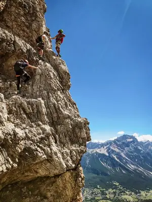 a group of people climbing on the side of a mountain at FIORI Dolomites Experience Hotel in San Vito di Cadore