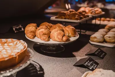 a table topped with plates of pastries and pies at FIORI Dolomites Experience Hotel in San Vito di Cadore