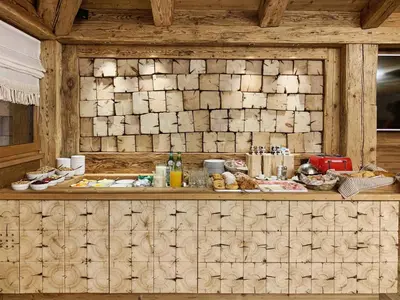 a buffet line with food on a wooden wall at FIORI Dolomites Experience Hotel in San Vito di Cadore
