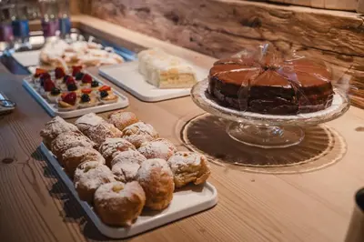 a table topped with different types of pastries and cakes at FIORI Dolomites Experience Hotel in San Vito di Cadore