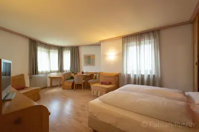 a hotel room with a bed and a table at Ciasa La Rô in San Cassiano