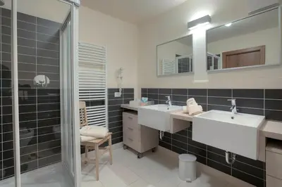 a bathroom with two sinks and a shower at Ciasa La Rô in San Cassiano