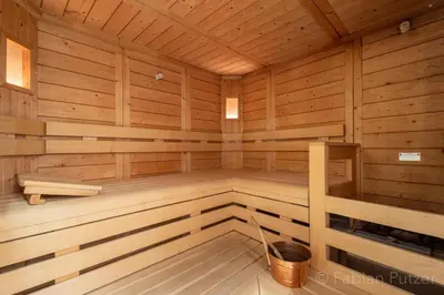 a wooden sauna with a bucket in the middle at Ciasa La Rô in San Cassiano