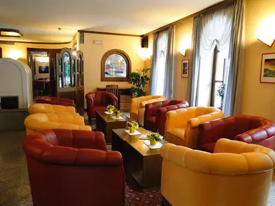a waiting room with couches and chairs at Albergo Dolomiti in Fiera di Primiero
