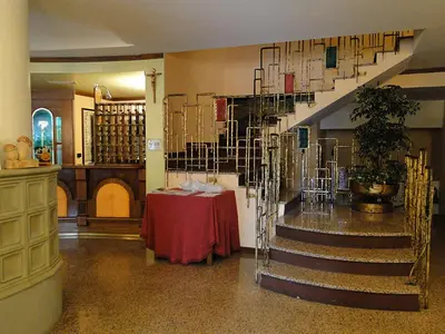 a room with a table and stairs in a building at Albergo Dolomiti in Fiera di Primiero