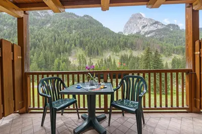 a table and chairs on a balcony with a view at Aparthotel Princess in Canazei