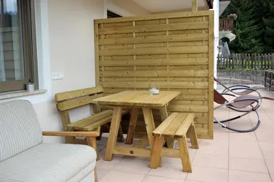 a wooden table and benches on a patio at Apartment Kristyn in Ortisei