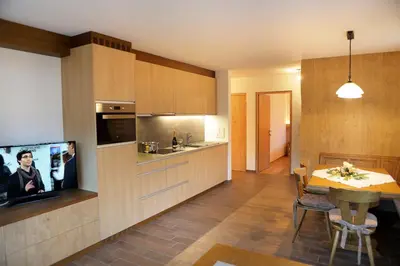 a kitchen with a table and a television and a dining room at Apartment Kristyn in Ortisei