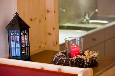 a candle in a nest next to a lantern on a table at Piculin Alpin Apartments in San Martino in Badia