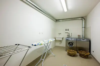 a laundry room with a washer and a washing machine at Piculin Alpin Apartments in San Martino in Badia