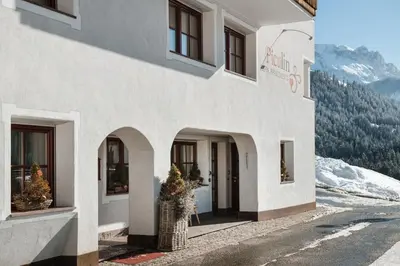 a white building with a doorway with a mountain at Piculin Alpin Apartments in San Martino in Badia