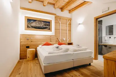 a bedroom with a bed with towels on it at Hotel Aurai in Telve