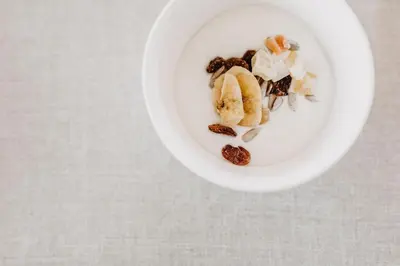 a white bowl filled with nuts and raisins at Hotel Aurai in Telve