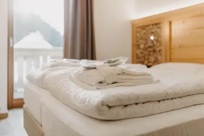a white bed with towels on top of it at Hotel Aurai in Telve