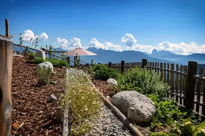 a garden with a fence and an umbrella at Obergruberhof in Chiusa