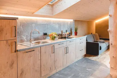 a kitchen with wooden cabinets and a sink at Obergruberhof in Chiusa