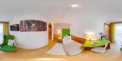 a living room with a couch and a table at Hotel Brunnerhof in Rasùn di Sotto