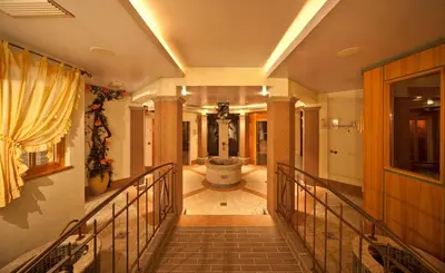a hallway with a staircase with a tub in a building at Hotel Brunnerhof in Rasùn di Sotto