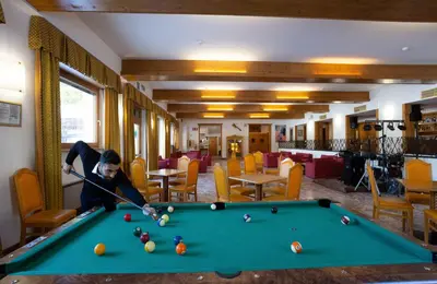 a restaurant with a large painting of a mountain at Hotel San Giusto in Falcade