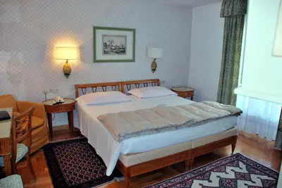 a bedroom with a large bed in a room at Hotel De La Poste in Cortina dʼAmpezzo
