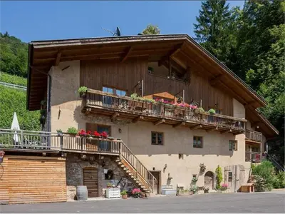 a house with a balcony with flowers on it at Lexnhof in Montagna