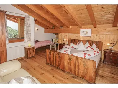a bedroom with a large bed in a wooden house at Lexnhof in Montagna