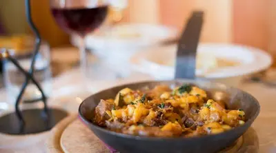 a bowl of food on a table with a glass of wine at Lexnhof in Montagna