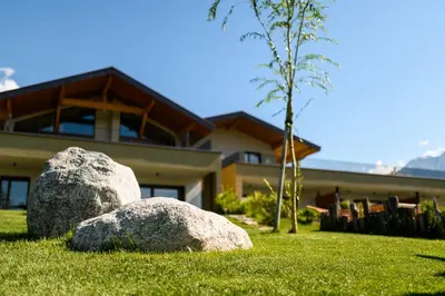 two rocks in the grass in front of a house at Pataunerhof Tirol in Tirolo