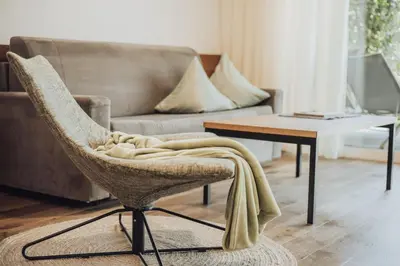 a living room with a chair and a couch at Pataunerhof Tirol in Tirolo