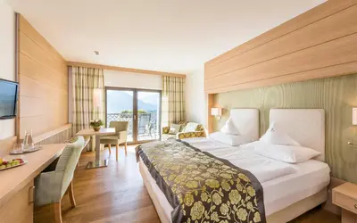 a hotel room with a large bed and a desk at Hotel Lagrein in Schenna