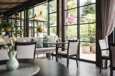 a restaurant with tables and chairs and a large window at Hotel Lagrein in Schenna