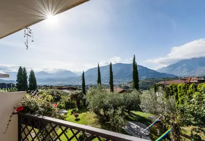 a view from the balcony of a house with trees and mountains at Hotel Lagrein in Schenna