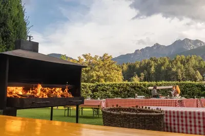 a fireplace in a yard with a table at Hotel Scherer in Valdaora