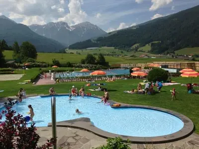 a group of people in a large swimming pool at Hotel Scherer in Valdaora