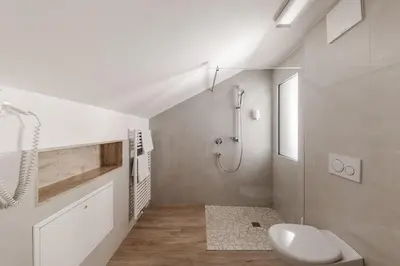 a white bathroom with a shower and a toilet at Hotel Oberwirt in Feldthurns