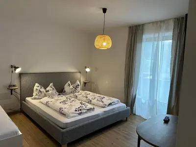 a bedroom with a bed with pillows and a table at Dolomites Smart Holidays in Valdaora