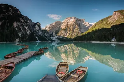 a group of boats on a lake with mountains at Dolomites Smart Holidays in Valdaora