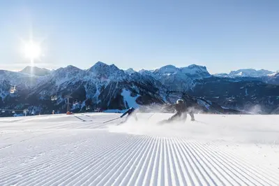 two people are skiing down a snow covered slope at Dolomites Smart Holidays in Valdaora